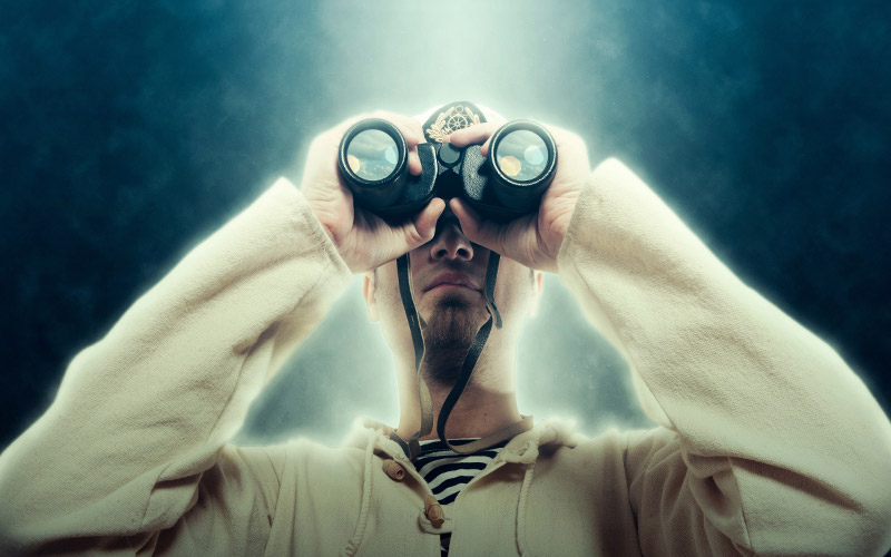 A man looking through binoculars