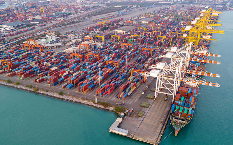 Busy container ship terminal with hundreds of stacked containers