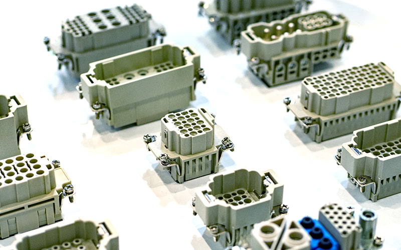 A collection of gray electrical connectors is displayed on a white surface.